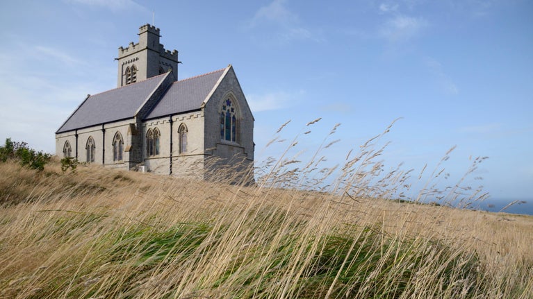 A church on a hill in a field of grass
